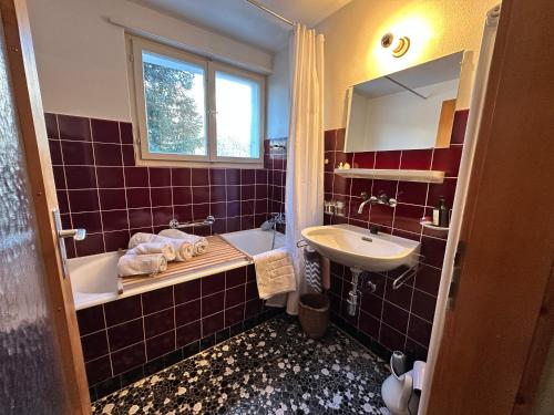 a bathroom with a sink and a tub and a mirror at Ferienwohnung Visoura in Parsonz