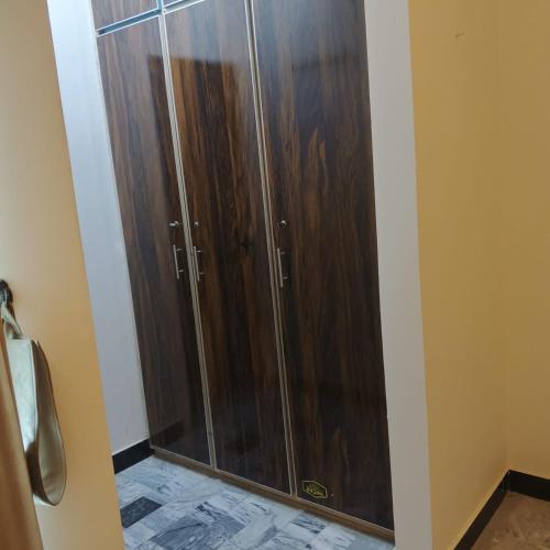 a shower with wooden doors in a bathroom at Wali Rest House 1 in Rahimyar Khan