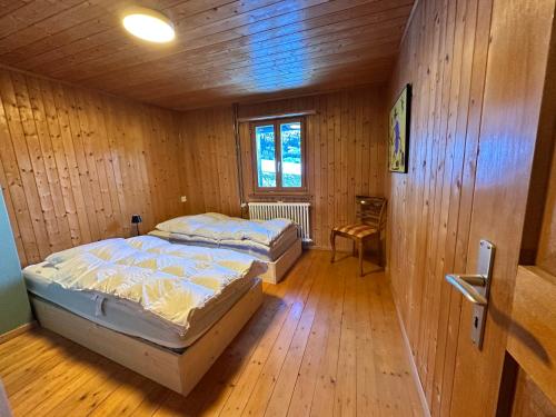 a bedroom with two beds and a chair in it at Ferienwohnung Visoura in Parsonz