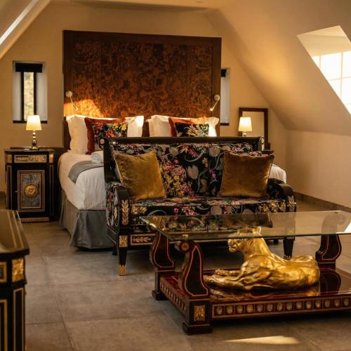 a bedroom with a bed and a couch and a table at Weston Manor Hotel in Bicester