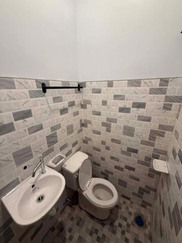 a bathroom with a toilet and a sink at New Apartment in Panglao Island