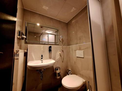a small bathroom with a toilet and a sink at Hotel Augustin Komfort Leipzig Ihr Zuhause unterwegs in Leipzig