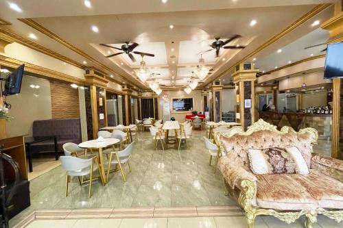 a hotel room with a bed and tables and chairs at Clark Imperial Hotel Angeles City in Angeles