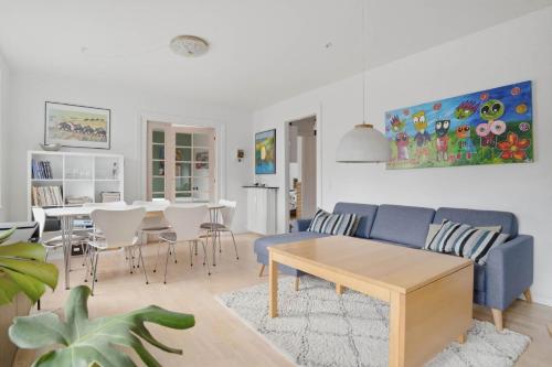 a living room with a blue couch and a table at Apartment in central Holstebro in Holstebro