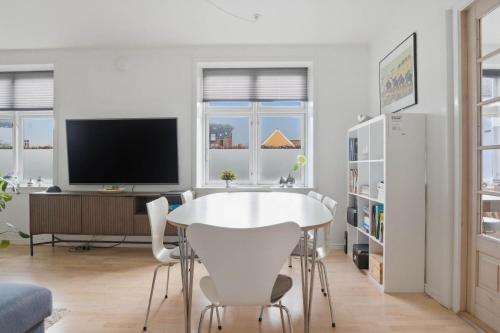 a white dining room with a white table and chairs at Apartment in central Holstebro in Holstebro