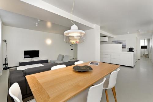 a dining room with a table and a couch at Urban Residences Maastricht in Maastricht