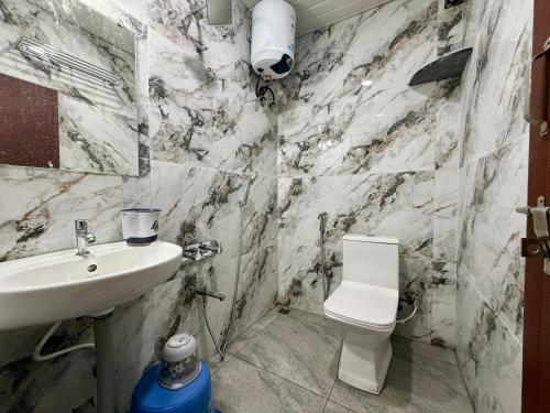 a white bathroom with a sink and a toilet at Kanasu Residency Malpe in Udupi