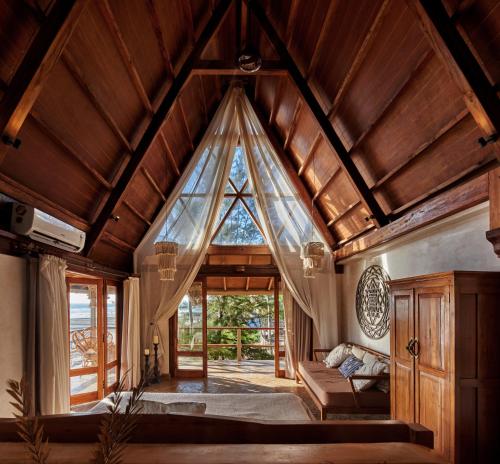 a bedroom with a large glass window in a room at Vaayu Kula mandrem in Mandrem