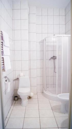a white bathroom with a toilet and a sink at Zajazd Przy Granicy in Słuczanka
