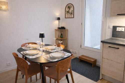 a dining room with a table with chairs and a kitchen at Appartement hyper Centre Rénové Terrasse & Parking in Tours