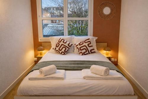 a bedroom with a bed with two pillows and a window at Appartement hyper Centre Rénové Terrasse & Parking in Tours