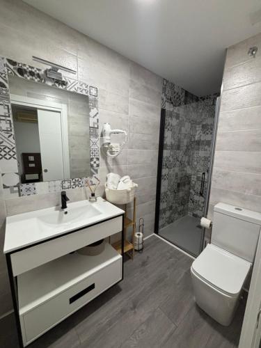 a bathroom with a sink and a toilet and a shower at Hostal Los Rosales in Tejeda de Tiétar