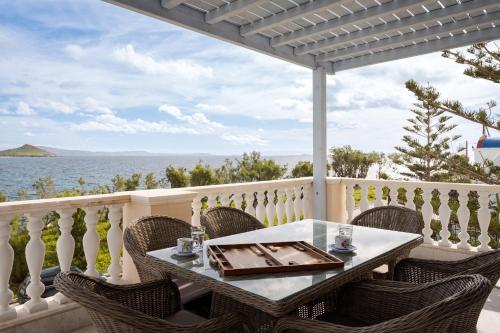 a table on a balcony with a view of the ocean at Seashore Villas Tinos in Tinos