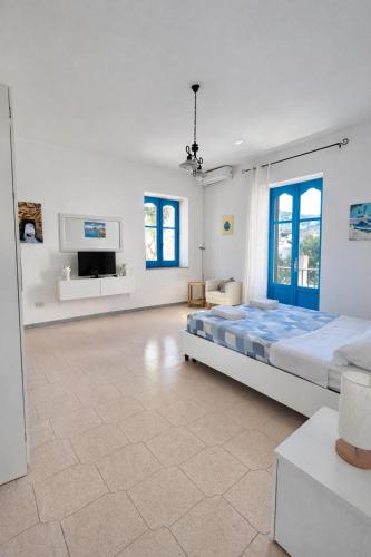 a bedroom with a large bed and a flat screen tv at Aeolian Apartments in Lipari