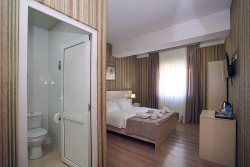 a hotel room with a bed and a toilet at Sport time Hotel & Spa in Tbilisi City