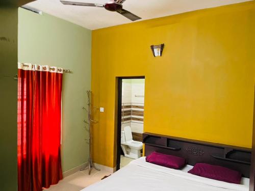 a bedroom with a bed and a red curtain at Clement homes in Kalpetta