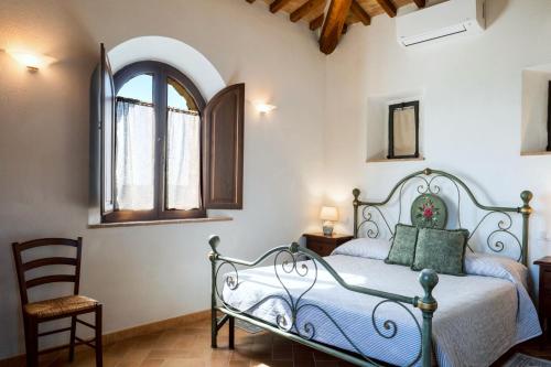 a bedroom with a bed and a chair and a window at Podere Montale Winery in Seggiano