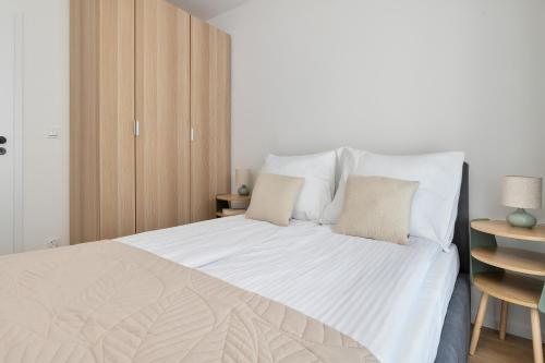 a bedroom with a large white bed with two pillows at Pino Resort Gdańsk by Solarento in Gdańsk