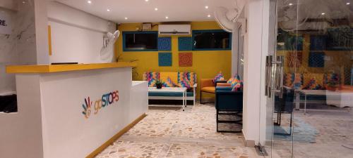 a living room with yellow walls and couches at goSTOPS PLUS Goa, Vagator in Old Goa