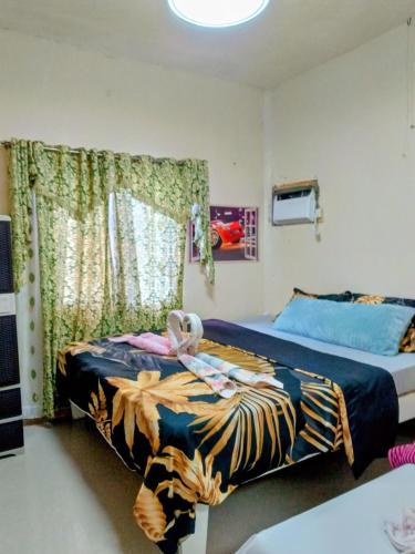 a bedroom with two beds with a stuffed animal on them at Camigs Vacation House in Mambajao