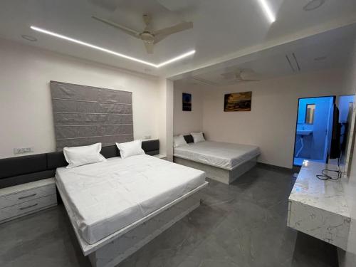 a bedroom with two beds and a tv in it at Hotel Tulsi in Aurangabad