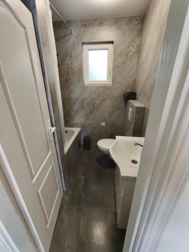 a small bathroom with a toilet and a sink at Little Village Loft in Káty