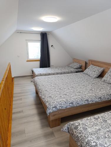 a bedroom with three beds and a window at Little Village Loft in Káty