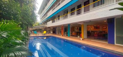 a swimming pool in front of a building at goSTOPS PLUS Goa, Vagator in Old Goa