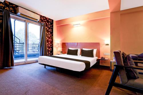 a bedroom with a large bed and a large window at Hotel Asian Near Delhi Airport in New Delhi