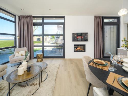 a living room with a table and chairs and a fireplace at Villa L-Meerzicht | 4 pers. in Workum