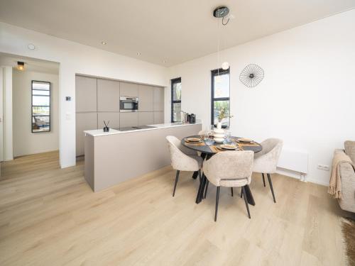 a kitchen and dining room with a table and chairs at Villa L-Meerzicht | 4 pers. in Workum
