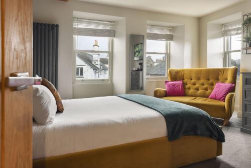 a bedroom with a bed and a yellow chair at The Hive at Poppi-Red in Hawkshead