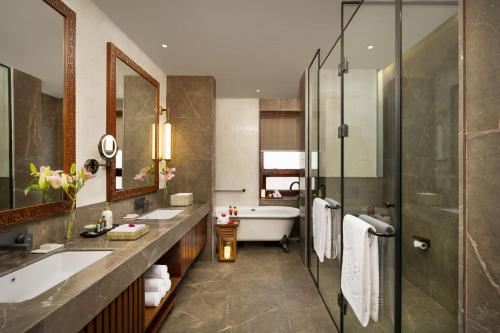 a bathroom with a tub and a sink and a shower at Taj Paro Resort & Spa in Paro