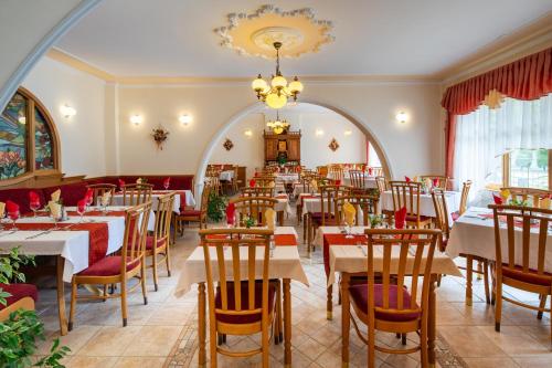 a restaurant with tables and chairs and a chandelier at Hajdú Kastély Hotel in Hajdúszoboszló