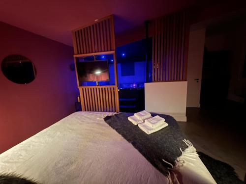 a bedroom with a bed with two towels on it at Love room Jacuzzi - Litchi in Bordeaux