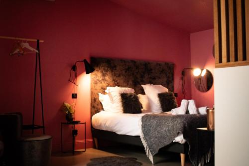 a red bedroom with a bed with white pillows at Love room Jacuzzi - Litchi in Bordeaux