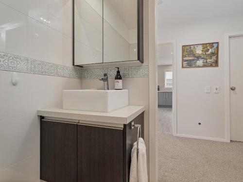 a bathroom with a sink and a white counter at Soleil Studio - Whangamata Self-contained Unit in Whangamata