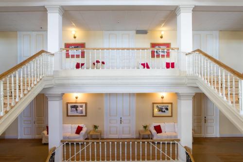 a spiral staircase in a house with couches at Maloja Palace Suites CO2-Neutral in Maloja