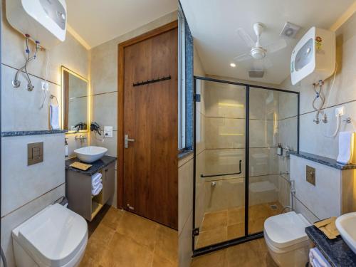 a bathroom with a shower and a toilet and a sink at S by Z Hotels, Baani Square in Gurgaon
