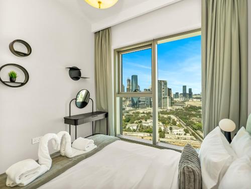 a bedroom with a large bed with a large window at Royal Vista - Luxury 4BR Apartment at Downtown Views II - Downtown in Dubai