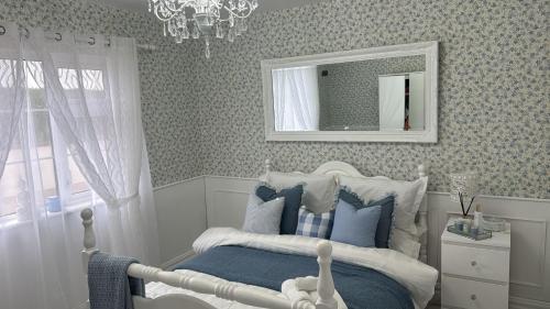 a bedroom with a bed and a mirror and a chandelier at Dernvale House -Double Room sleeps 2 in Mullinderg