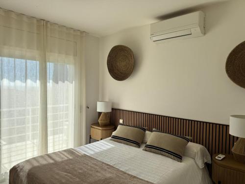 a bedroom with a bed with two pillows and a window at casa santa caterina in Torroella de Montgrí