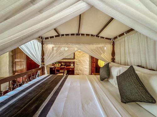 a bedroom with a large bed in a room at Heenatigala Walawwa - Free Shuttle to Our Private Beach in Talpe