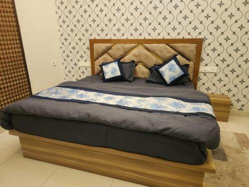 a bed with blue pillows on it in a bedroom at pearl green's in Anandpur Sāhib