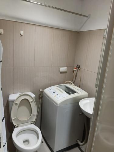 a small bathroom with a toilet and a sink at Shell Residences MOA by Joseph in Manila