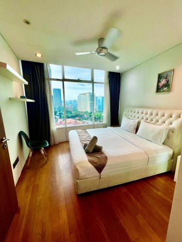 a bedroom with a large bed with a large window at Apartment klcc area in Kuala Lumpur