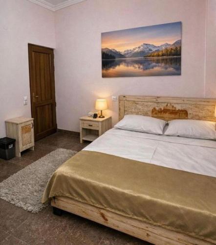 a bedroom with a bed and a painting on the wall at Republic Square In Hotel California in Yerevan