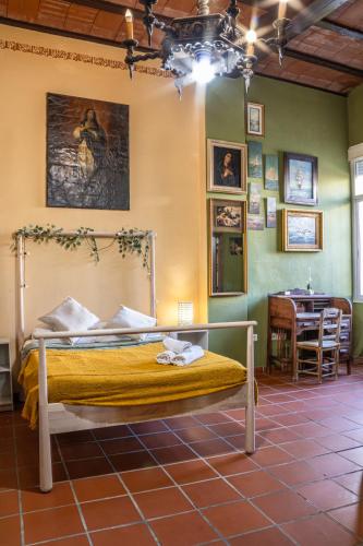 a bedroom with a bed in a room with a table at La Posada de Zepeda in Jerez de la Frontera