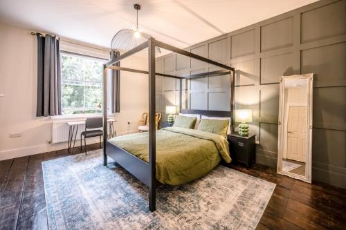 a bedroom with a canopy bed and a desk at The Leiston, High Street in Leiston