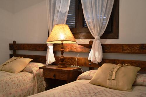 Casa Anina في Montsonis: غرفة نوم بسريرين ومصباح ونافذة